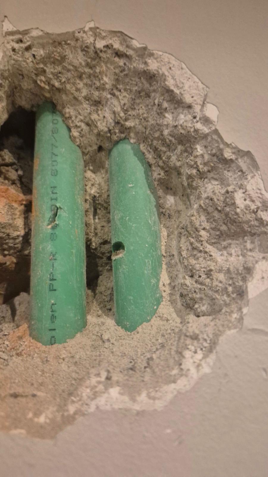 Dos tuberías empotradas con perforaciones visibles antes de la intervención